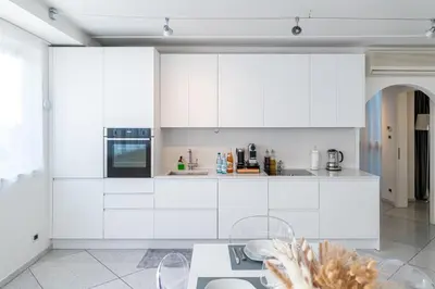 a kitchen with white cabinets and a table at Artist House in Merano