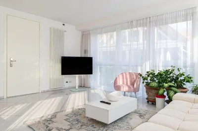a living room with a white couch and a tv at Artist House in Merano