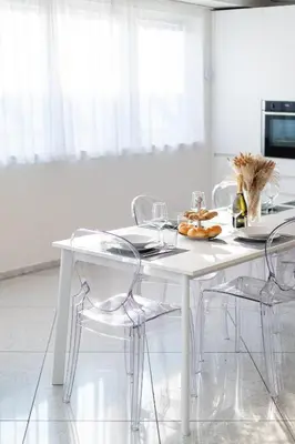 a white dining room table with chairs and a plate of food at Artist House in Merano