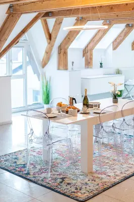 a dining room with a table and chairs on a rug at Artist House in Merano