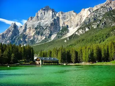 a large green lake in front of a mountain at Ciasa Coleto in San Vito di Cadore