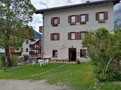 a large house with a table and chairs in the yard at Ciasa Coleto in San Vito di Cadore