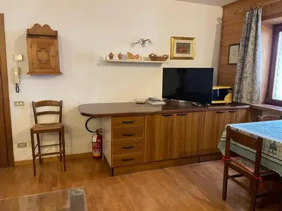 a bedroom with a desk with a television and a bed at Ciasa Coleto in San Vito di Cadore