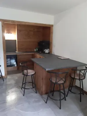 a kitchen with a table and two bar stools at Roda de Vael in Moena