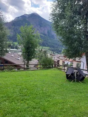 a picnic table in a field with a view of a mountain at Roda de Vael in Moena
