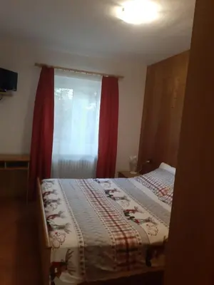 a bedroom with a bed and a window with red curtains at Roda de Vael in Moena