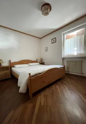 a bedroom with a large bed and a window at Casa Canazei, 2-5 pers Appartement 122 in Canazei