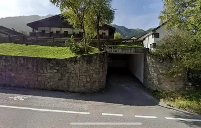 a tunnel with a stone wall next to a road at Casa Canazei, 2-5 pers Appartement 122 in Canazei