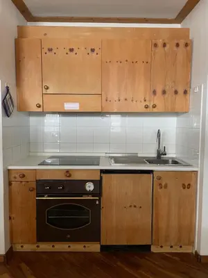 a kitchen with wooden cabinets and a stove and a sink at Casa Canazei, 2-5 pers Appartement 122 in Canazei