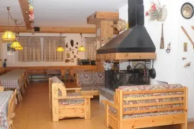 a living room with a fireplace and tables and chairs at Casa Canazei, 2-5 pers Appartement 122 in Canazei