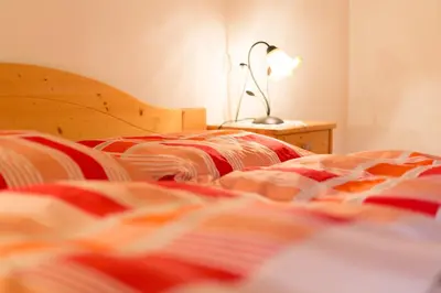 a bedroom with two beds and a lamp on a table at Mahrhof zu Adlitzhausen in Scandole