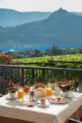a table with food and orange juice on a balcony at Garni Osannahöfl in Caldaro