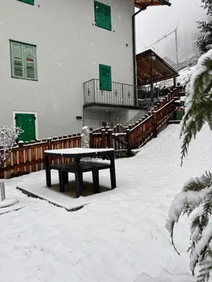 a bench in the snow in front of a building at Appartamento Maria appartamento nelle dolomiti in Canale San Bovo