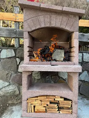 a stone oven with a pile of wood in it at Appartamento Maria appartamento nelle dolomiti in Canale San Bovo