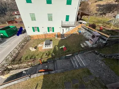 a house with a small garden in front of it at Appartamento Maria appartamento nelle dolomiti in Canale San Bovo