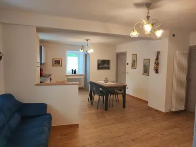 a living room with a table and a blue couch at Appartamento Maria appartamento nelle dolomiti in Canale San Bovo