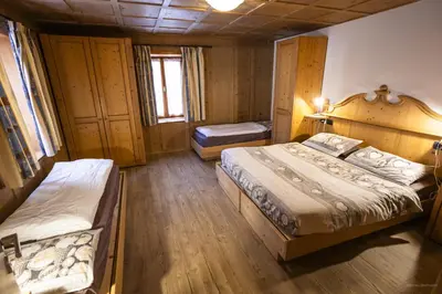 a dining room with a wooden table and chairs at appartamenti dei Maerins in Pozza di Fassa