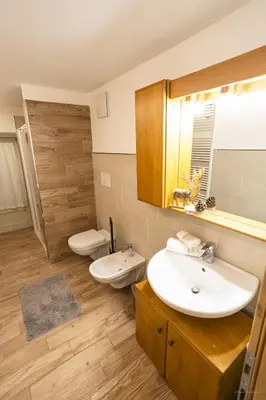 a bedroom with two beds and a table and a table sidx sidx sidx at appartamenti dei Maerins in Pozza di Fassa