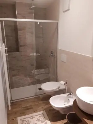 a bathroom with two sinks and a toilet at appartamenti dei Maerins in Pozza di Fassa