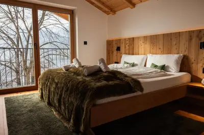 a bedroom with a bed and a large window at Chalet Astra, Whirlpool & Sauna in San Pancrazio dʼUltimo