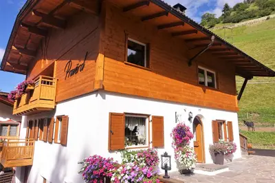 a house with flowers in front of it at Apartments Praverd nelle Dolomiti in Santa Cristina in Val Gardena