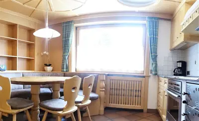 a kitchen with a table and chairs and a window at Apartments Praverd nelle Dolomiti in Santa Cristina in Val Gardena