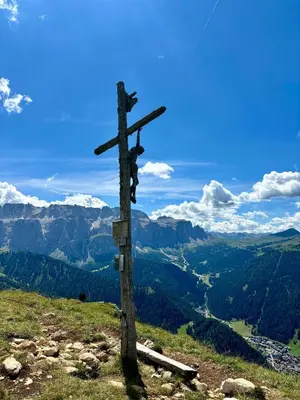 a wooden cross on the top of a mountain at Apartments Praverd nelle Dolomiti in Santa Cristina in Val Gardena