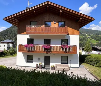 a building with a balcony with flowers on it at Apartments P19 nelle Dolomiti in Ortisei