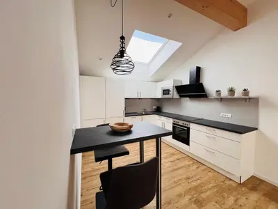 a kitchen with white cabinets and a black counter top at Apartments P19 nelle Dolomiti in Ortisei