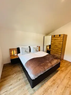 a bedroom with a large bed with wooden floors at Apartments P19 nelle Dolomiti in Ortisei
