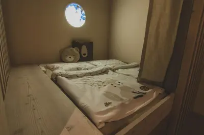 a bed in a room with a small window at O'Mama family time - am Eggerhof in Mühlbach