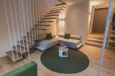 a living room with a couch and a spiral staircase at O'Mama family time - am Eggerhof in Mühlbach
