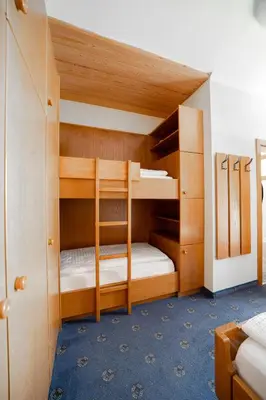 a bunk room with two bunk beds in it at Hotel Euròpa Dolomites in Selva di Val Gardena
