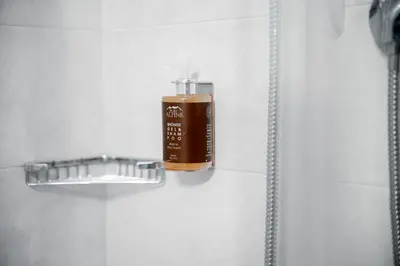 a bottle of soap in a shower stall at Hotel Euròpa Dolomites in Selva di Val Gardena