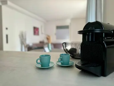 two cups on a counter next to a coffee maker at Lilena Apartment in Merano