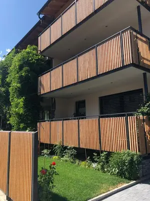 a house with a wooden fence and a yard at Lilena Apartment in Merano