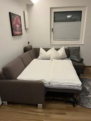 a bed in a living room with a couch at Lilena Apartment in Merano