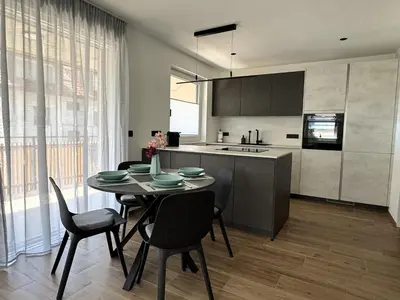 a kitchen and dining room with a table and chairs at Lilena Apartment in Merano