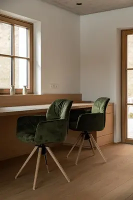two green chairs sitting at a desk in a room at Haus Engadein in Auna di Sopra
