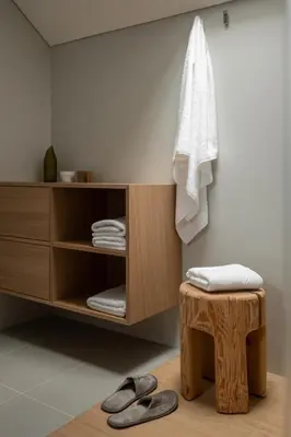 a bathroom with a shelf with towels and a stool at Haus Engadein in Auna di Sopra