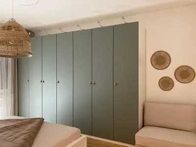 a bedroom with green cabinets and a bed at Apartment Larissa in Merano