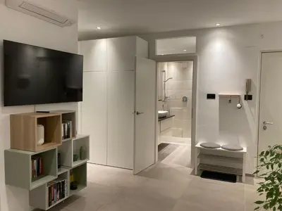 a bathroom with a television and a bathroom with a shower at Apartment Larissa in Merano