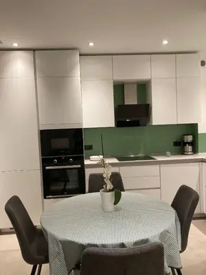 a kitchen with a table and chairs and a kitchen with white cabinets at Apartment Larissa in Merano