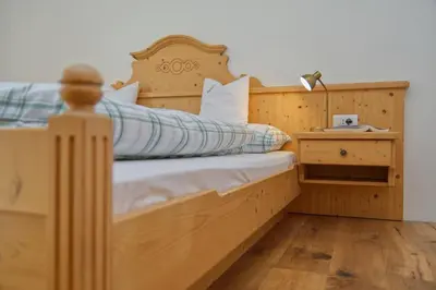 a wooden bed with a wooden headboard and a night stand at Hofrichter in San Lorenzo di Sebato