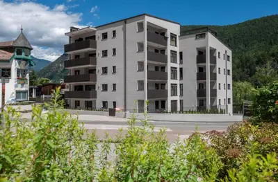 two tall apartment buildings with mountains in the background at SiJa in Mühlbach