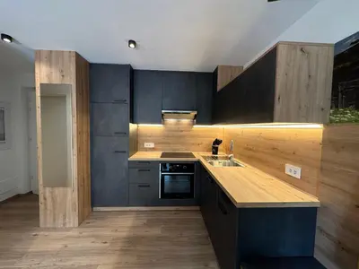 a kitchen with black cabinets and a wooden counter top at SiJa in Mühlbach