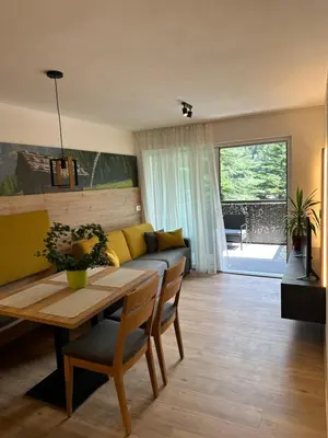 a living room with a table and a yellow couch at SiJa in Mühlbach