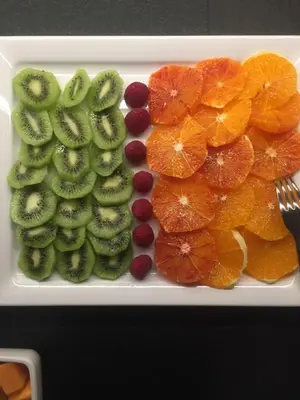 a plate with kiwi oranges and kiwi fruit at Hotel Garni Broi - Charme & Relax in Selva di Val Gardena