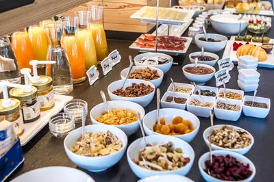 a buffet with many bowls of food on a table at Hotel Garni Broi - Charme & Relax in Selva di Val Gardena