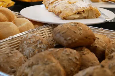 a table with two plates of pastries and bread at Hotel Garni Broi - Charme & Relax in Selva di Val Gardena